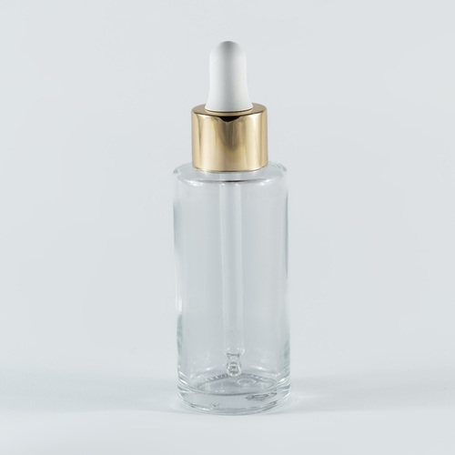 Transparent glass bottle with a golden pippet - 50ml